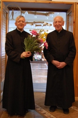 Hol przed Kaplicą, ks. Antoni trzyma bukiet kwiatów obok stoi ks. Edward