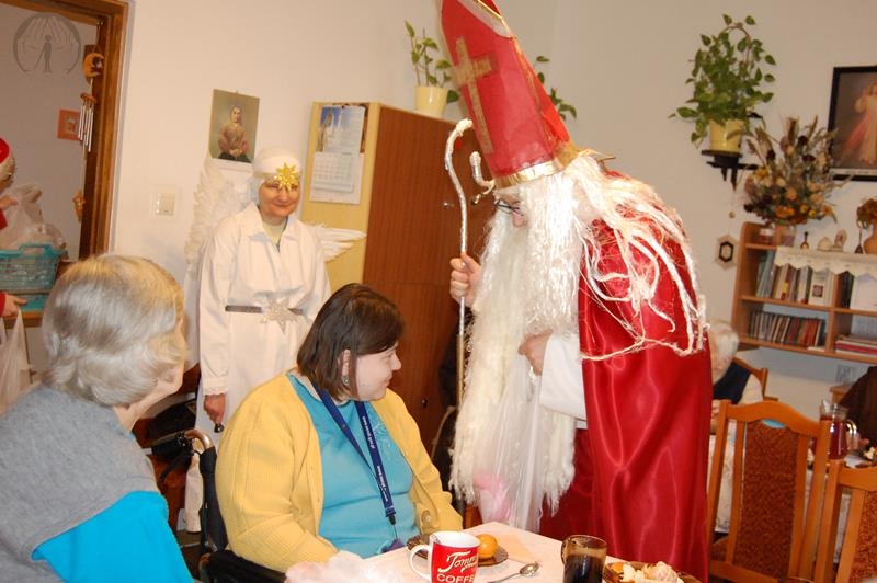 Dom Nadziei, świetlica skrzydła św. Bernadetty, Święty Mikołaj rozmawia z Panią Wiolettą, w tle stoi Aniołek