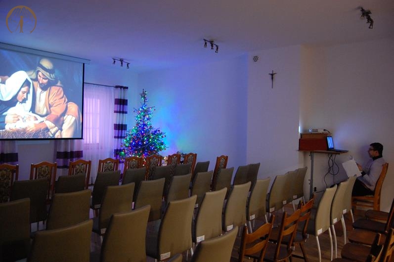 Sala muzykoterapii, pan Piotr w czasie ostatnich prób obsługi projektora wyświetla na ekranie obraz Świętej Rodziny