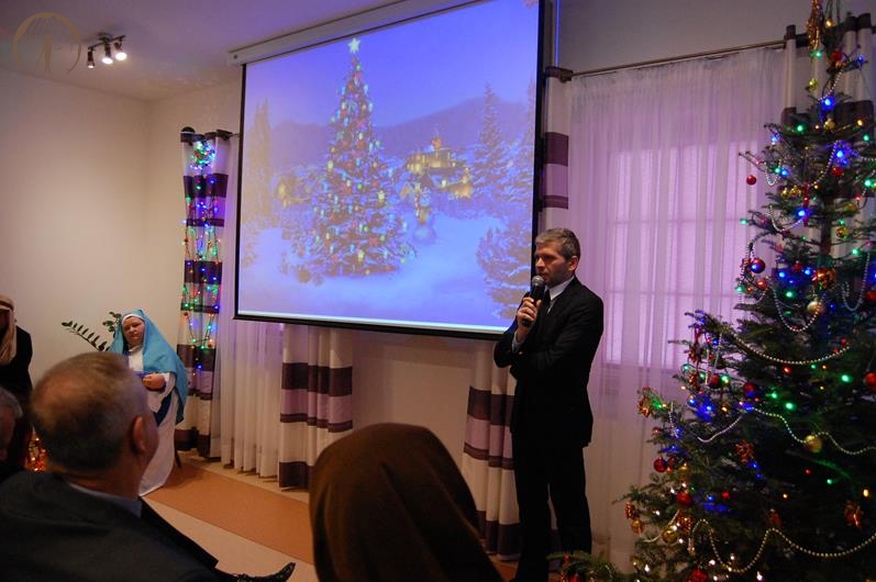 Sala muzykoterapii, pan Paweł Kacprzyk Prezes TOnOS zwraca się do Zgromadzonych, na ekranie wyświetlony obraz świątecznej choinki