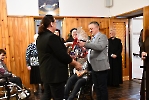 Hol przy kaplicy Domu Nadziei. Pan Tomasz wręcza Pani Agnieszce kosz słodyczy.
