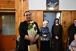 Hol przy kaplicy Domu Nadziei. Pani Agnieszka z bukietem kwiatów.