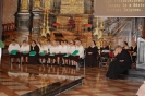 Środkowa część prezbiterium za ołtarzem siedzi w półokręgu chór Słoneczny Krąg, z prawej strony ks. Andrzej Gałka z siedzi z pochyloną głową w zadumie