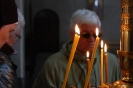 Wnętrze Prawosławnego Monastyru Zwiastowania Przenajświętszej Bogurodzicy w Supraślu, zapalone świece wotywne w tle twarze pań