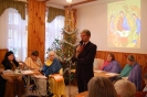 Świetlica Domu Nadziei, pierwszy plan Pan Paweł Kacprzyk Prezes TOnOS mówi przez mikrofon do zebranych, drugi plan scena na której znajduje się Wspólnota Koła Biblijnego