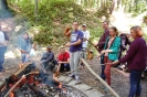 Uczestnicy spotkania pieką kiełbaski nad ogniskiem