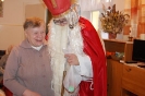 Dom Nadziei, świetlica skrzydła św. Barbary, Pani Krystyna uśmiechnięta stoi przy Świętym Mikołaju