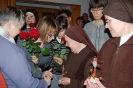 Hol przed kaplicą, Pani Katarzyna pomaga Pani Stanisławie wręczyć różę Siostrze Weronice, obok stoi Siostra Iwona, w tle stoją Pani Edyta, Siostra Rufina i Pracownicy