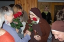 Hol przed kaplicą, Pani Katarzyna pomaga Pani Stanisławie wręczyć różę Siostrze Rufinie