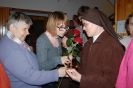 Hol przed kaplicą, Pani Katarzyna pomaga Pani Stanisławie wręczyć różę Siostrze Iwonie