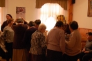 Świetlica w Domu Nadziei, uczestnicy spotkania przy stole z pamiątkami oglądają menorę, przymierzają jarmułkę, zadają pytania 