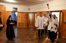 Hol przed Kaplicą, ks. Antoni dokonuje poświęcenia, obok idzie ministrant z wodą święconą