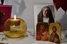 Ołtarzyk kolędowy, obrazek Matki Bożej z Dzieciątkiem Jezus na rękach, obraz bł. Matki Elżbiety, zapalona świeca 
