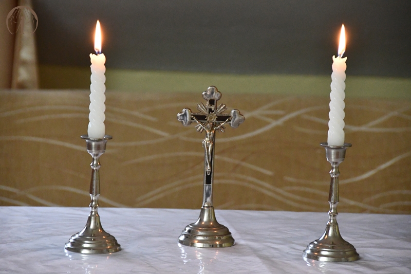 Ołtarzyk kolędowy, krucyfiks, zapalone świece