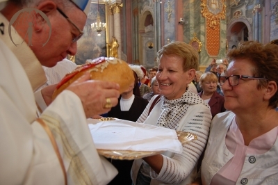 Ks. abp Stanisław Budzik całuje chleb ofiarowany w procesji darów